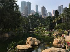 02A Artificial lake surrounded by trees with skyscrapers beyond in Hong Kong Park